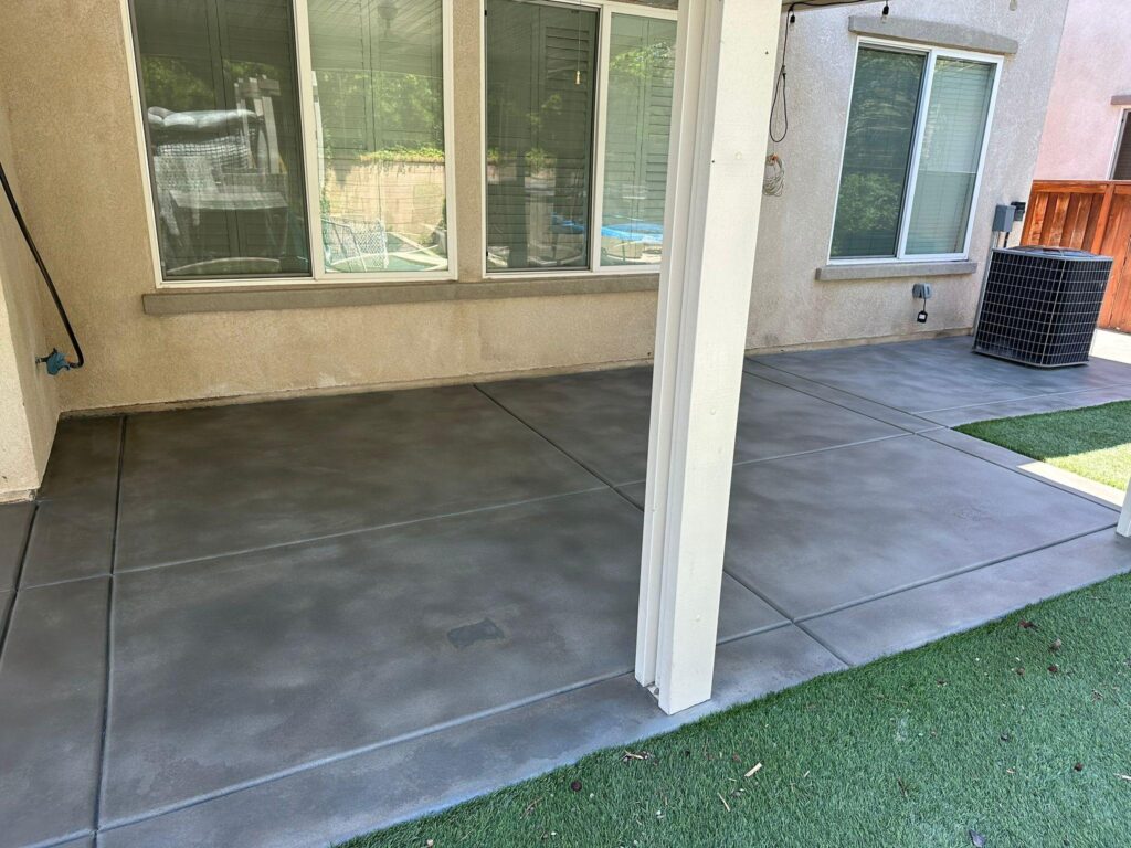Dark broom-finished concrete patio under a covered porch in Fayetteville, NC