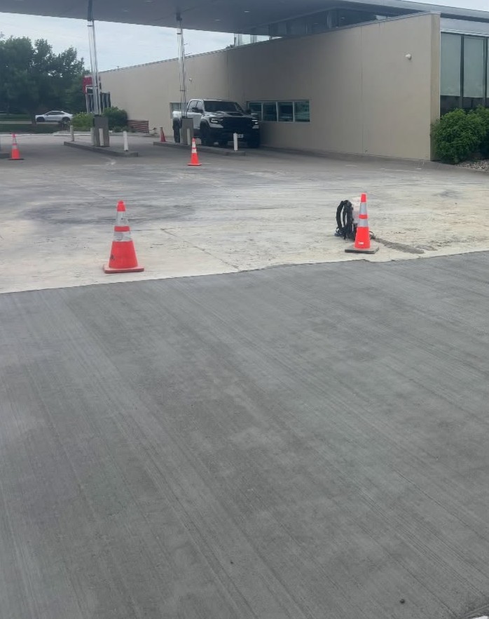 Commercial concrete parking lot marked with cones near a building in Fayetteville, NC