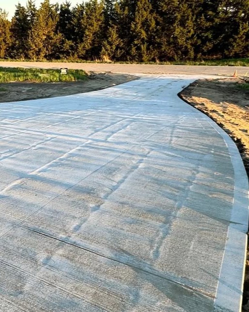 Newly constructed wet concrete driveway shining after finishing in Fayetteville, NC