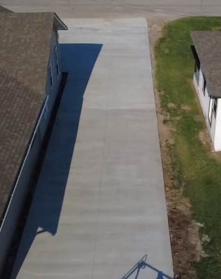 Long narrow concrete driveway alongside a lawn in Fayetteville, NC