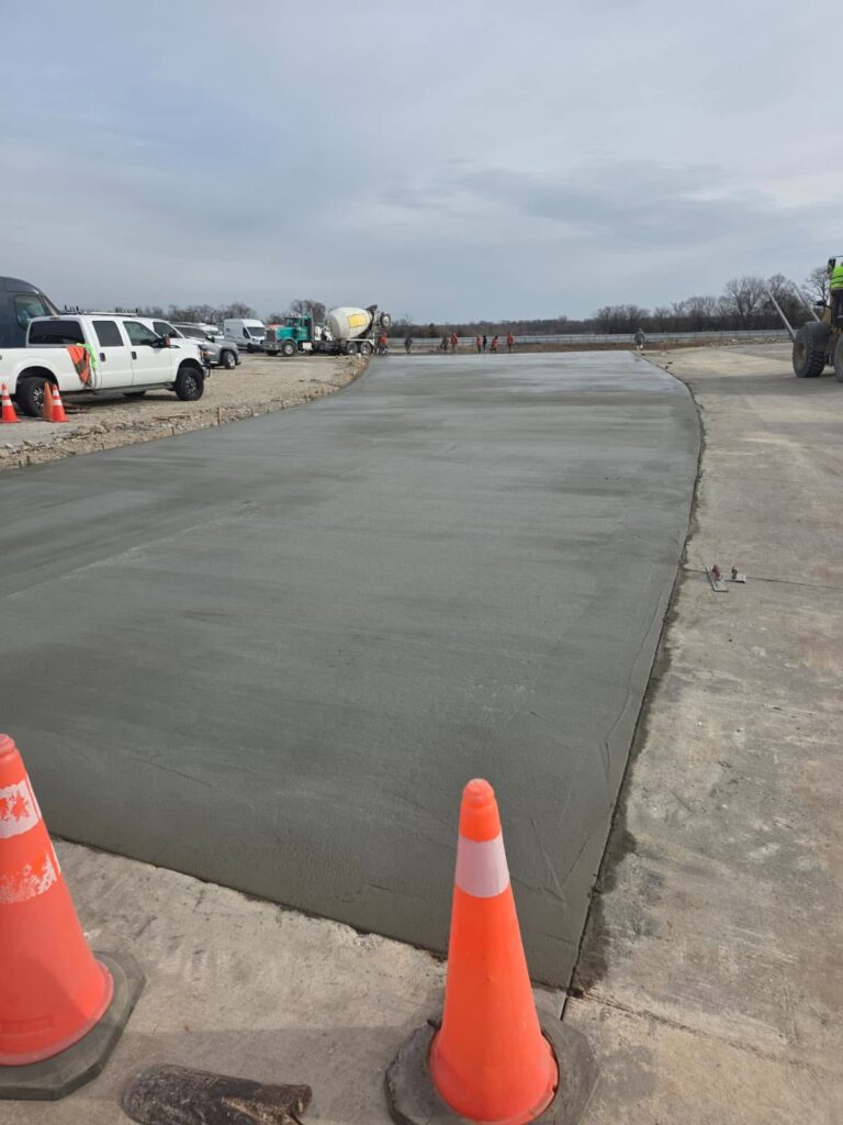 Newly poured concrete lot with safety cones marking the curing area in Fayetteville, NC