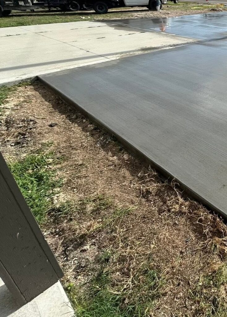 Newly poured concrete sidewalk along a residential yard in Fayetteville, NC